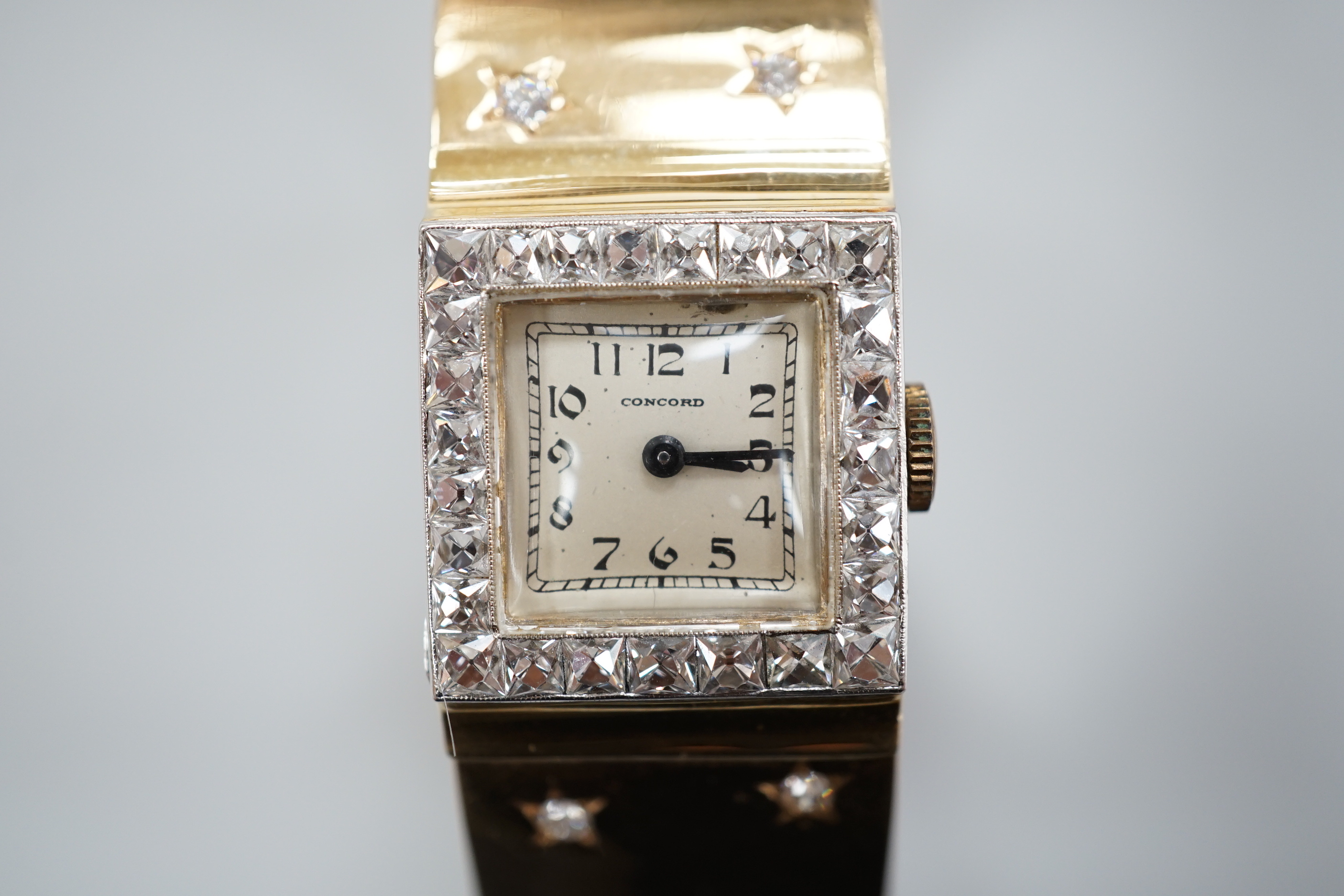 A yellow metal and diamond set Concorde manual wind open bracelet watch, with diamond set bezel and bracelet, gross weight 47.8 grams.